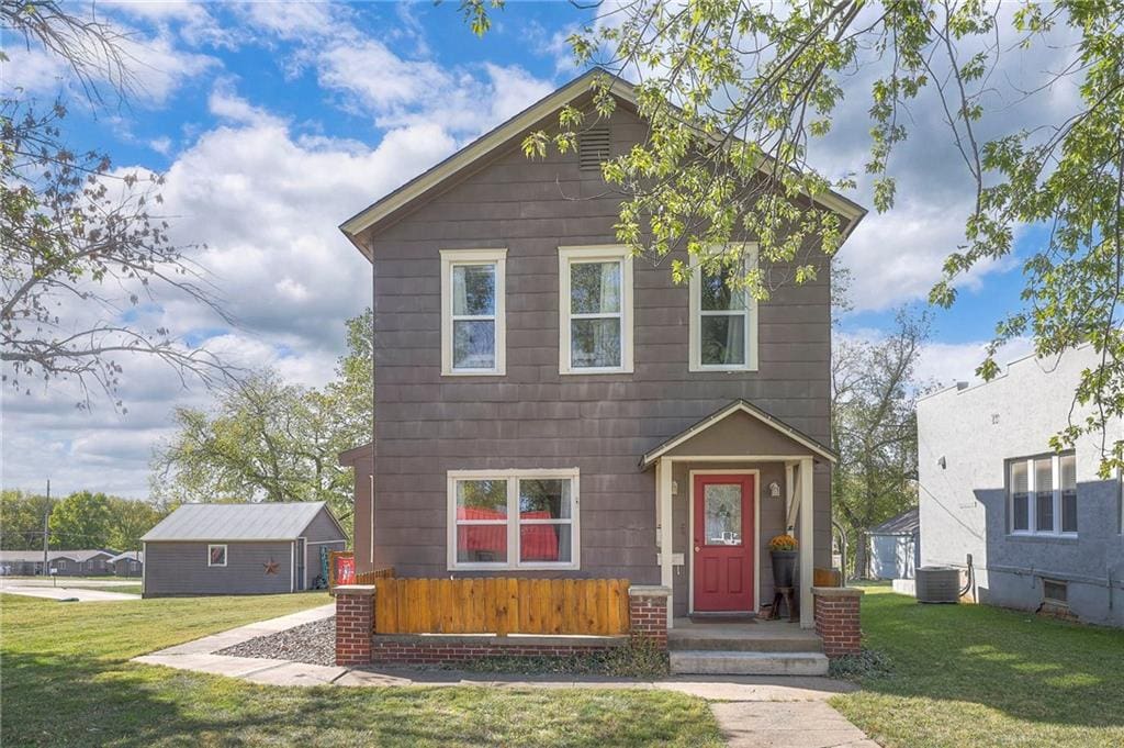 view of front of house featuring a front yard and central AC