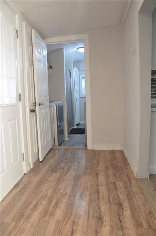 hallway with washer / clothes dryer and hardwood / wood-style flooring