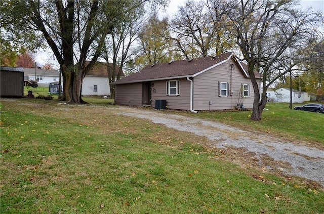 view of side of property featuring central air condition unit and a lawn