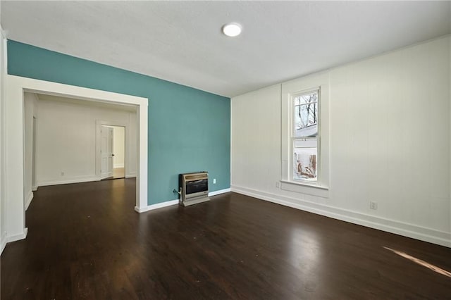 spare room featuring dark hardwood / wood-style flooring and heating unit