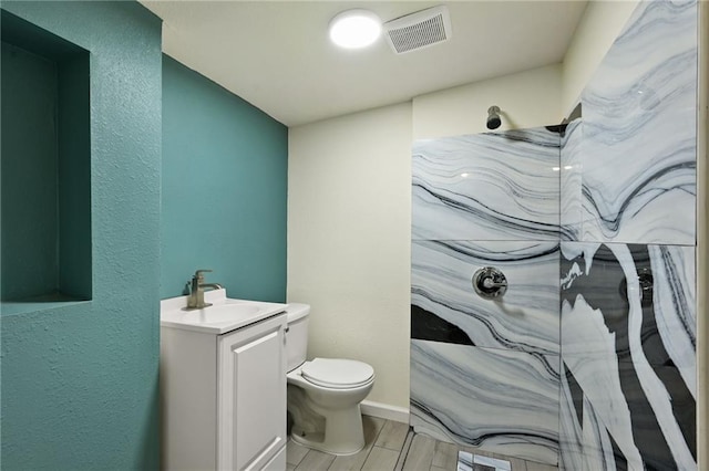 bathroom featuring a shower, vanity, and toilet