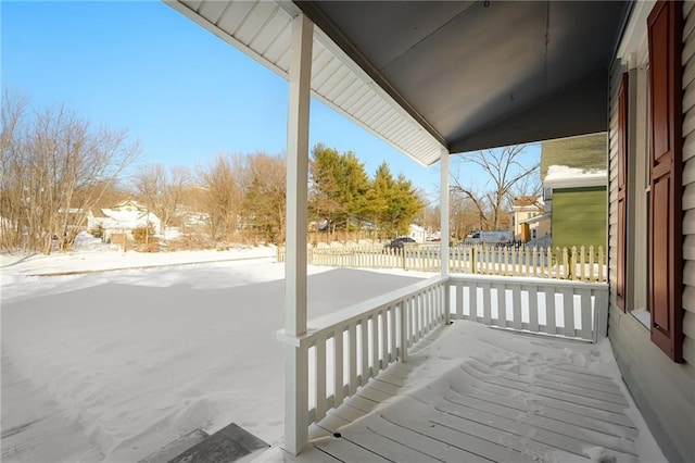 snow covered deck featuring a porch