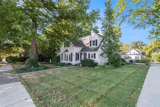 cape cod home featuring a front yard