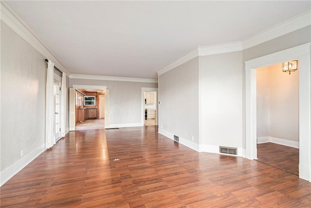 spare room with dark hardwood / wood-style floors, a chandelier, and crown molding