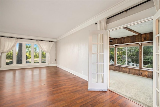 empty room featuring wood walls, crown molding, and hardwood / wood-style floors