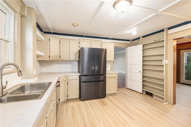 kitchen with cream cabinets, sink, stainless steel appliances, and light hardwood / wood-style flooring