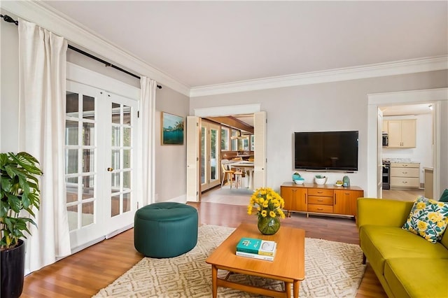 living room featuring french doors, ornamental molding, and wood-type flooring