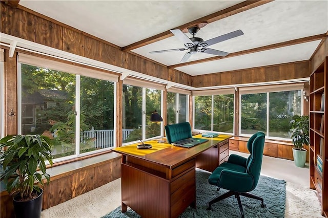 office space featuring carpet, a healthy amount of sunlight, beam ceiling, and wood walls