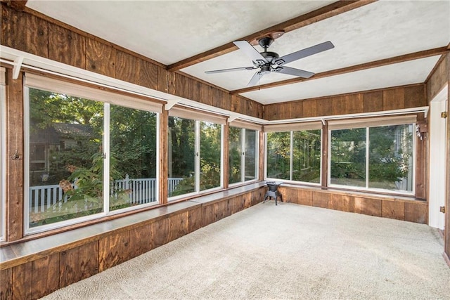 unfurnished sunroom with ceiling fan and beam ceiling