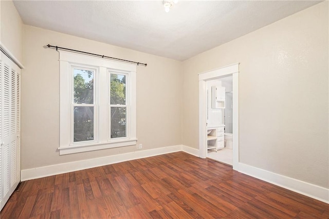 unfurnished room with dark wood-type flooring