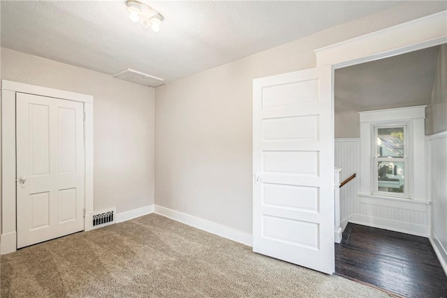 empty room with carpet and a textured ceiling