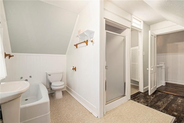 bathroom featuring vaulted ceiling, plus walk in shower, wood-type flooring, and toilet