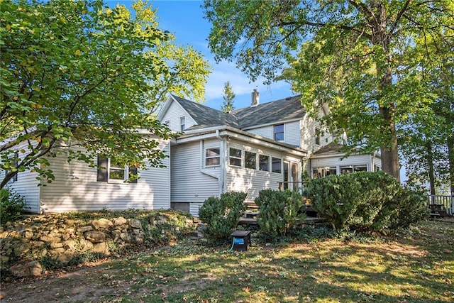 rear view of house featuring a sunroom