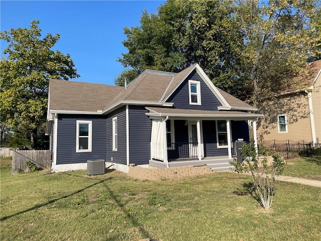 view of front of house featuring central air condition unit, a front yard, and covered porch