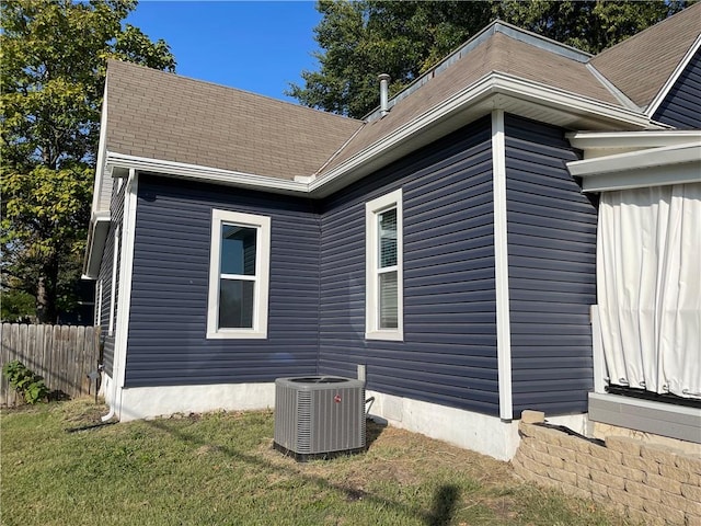 view of property exterior with cooling unit and a yard