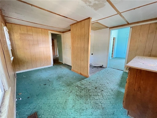 empty room featuring dark carpet and wooden walls