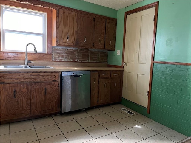 kitchen with light tile patterned floors, sink, tasteful backsplash, and stainless steel dishwasher