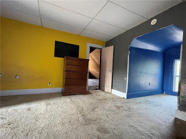 unfurnished bedroom with a drop ceiling and carpet