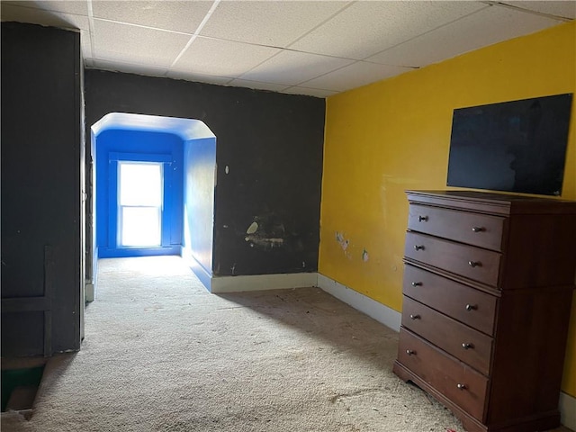 carpeted empty room featuring a drop ceiling