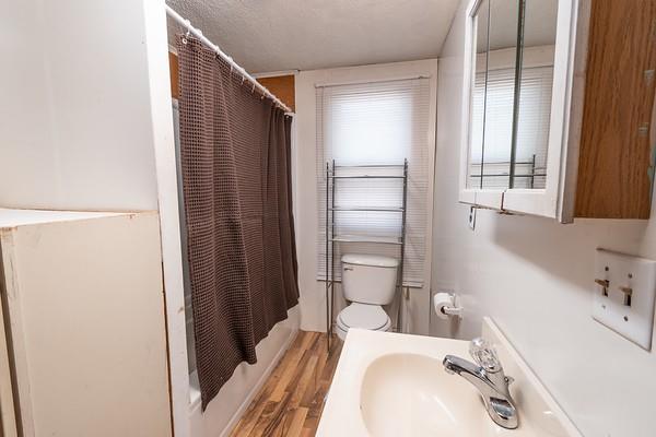 full bathroom with shower / bath combo with shower curtain, hardwood / wood-style floors, sink, and toilet