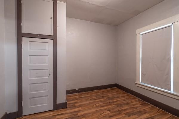 empty room with dark hardwood / wood-style flooring