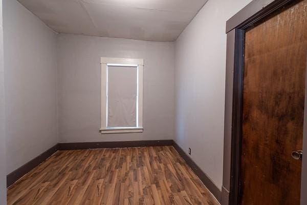 unfurnished room with dark hardwood / wood-style flooring