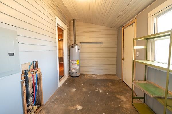 interior space with gas water heater, electric panel, wood walls, and wood ceiling