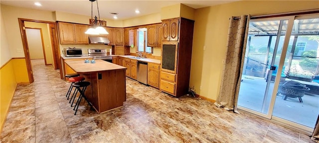 kitchen with a center island, extractor fan, stainless steel appliances, light countertops, and a sink