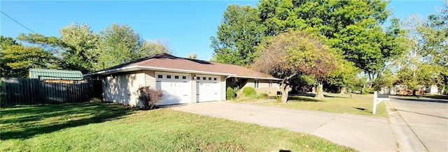 view of home's exterior featuring driveway, a garage, fence, and a yard