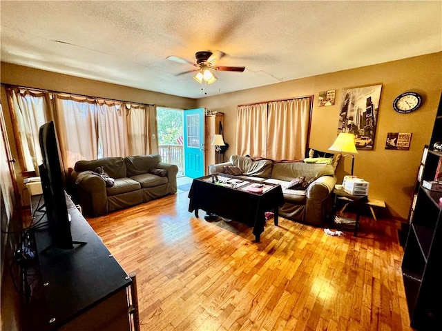 living room with hardwood / wood-style floors, a textured ceiling, and ceiling fan