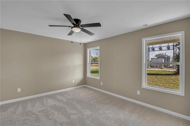 empty room with ceiling fan and light carpet