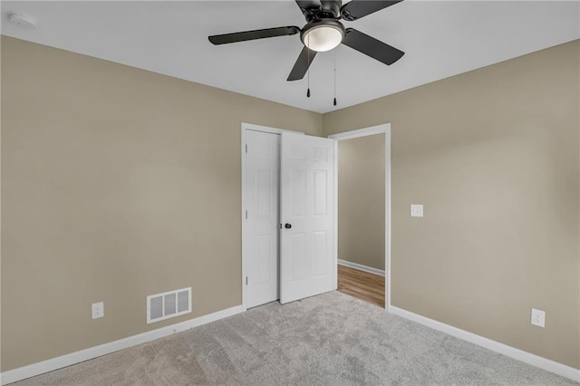 unfurnished bedroom featuring light colored carpet and ceiling fan