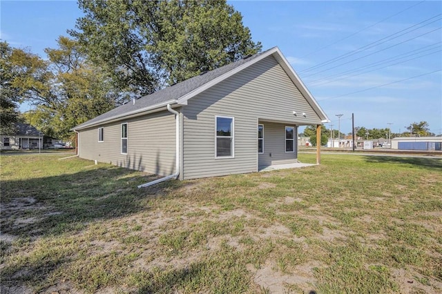 rear view of property featuring a lawn