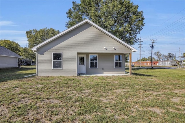 rear view of property featuring a lawn