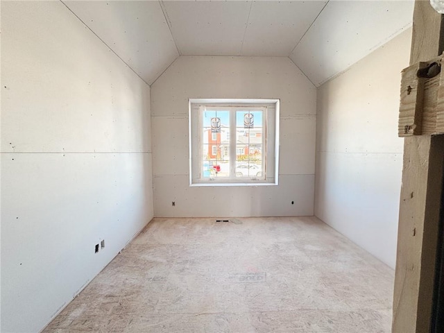 unfurnished room with vaulted ceiling