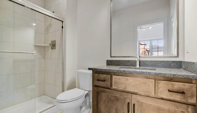 full bath featuring vanity, a shower stall, and toilet