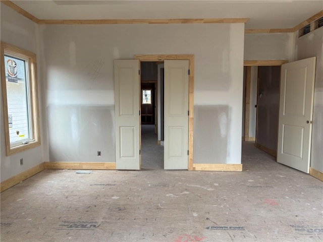 unfurnished room with baseboards