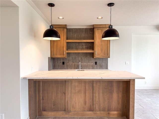 kitchen with open shelves, light stone counters, brown cabinetry, and recessed lighting