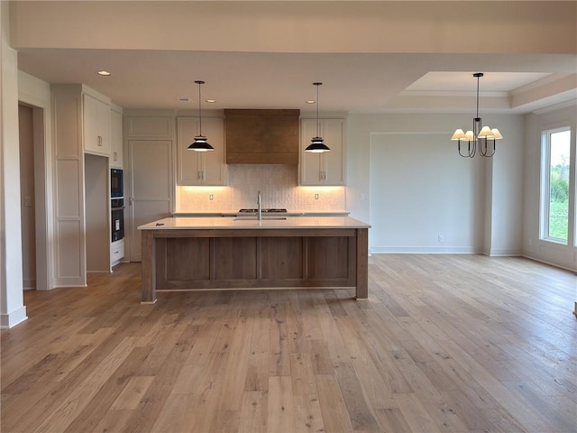 kitchen featuring light countertops, white cabinets, light wood-type flooring, and oven