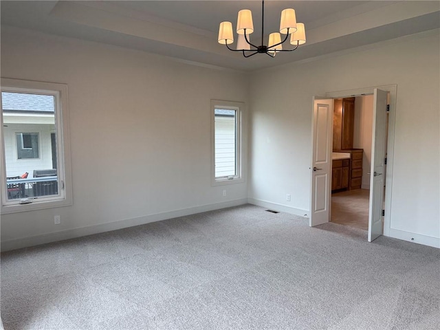 unfurnished room featuring visible vents, light colored carpet, baseboards, a raised ceiling, and a chandelier