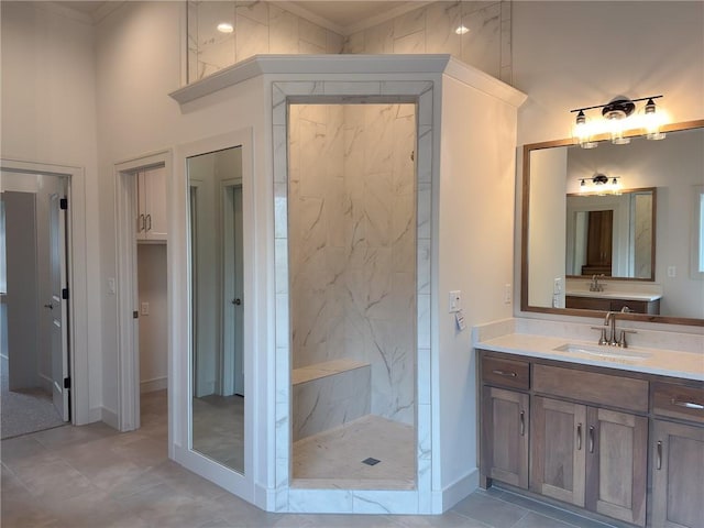 full bathroom with baseboards, ornamental molding, a marble finish shower, and vanity