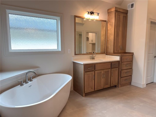 full bathroom with visible vents, tile patterned floors, vanity, and a soaking tub