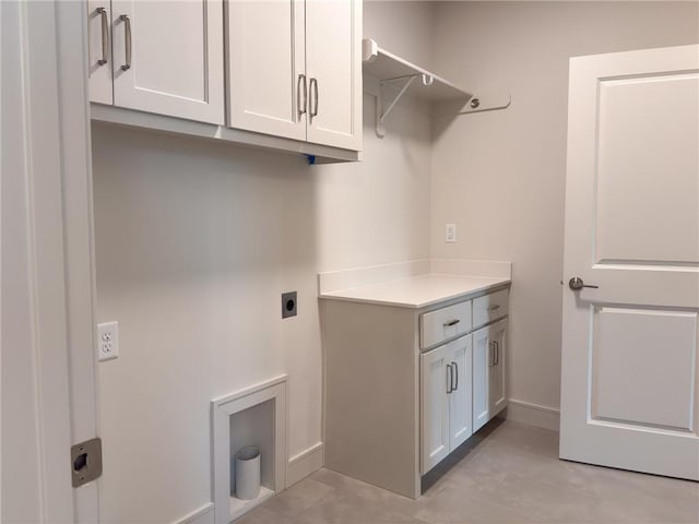 laundry area with light tile patterned floors, baseboards, electric dryer hookup, and cabinet space