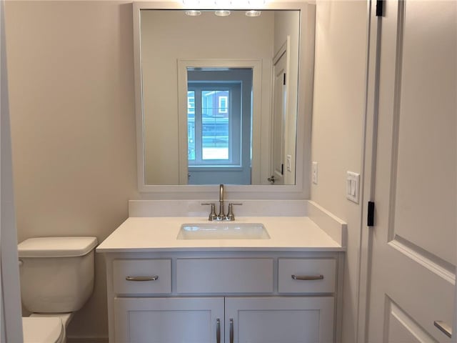 half bathroom with vanity and toilet