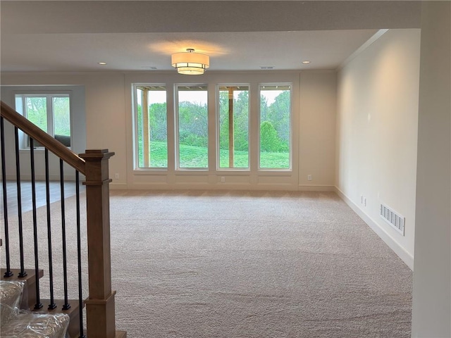 interior space with visible vents, ornamental molding, carpet, and baseboards