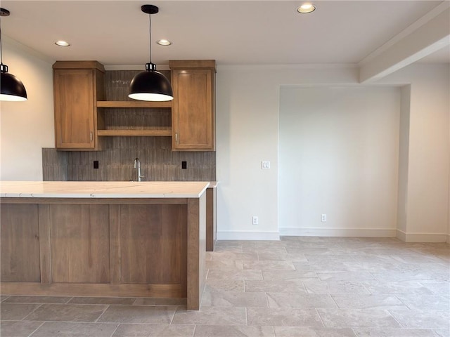 kitchen featuring crown molding, stone tile floors, and light countertops