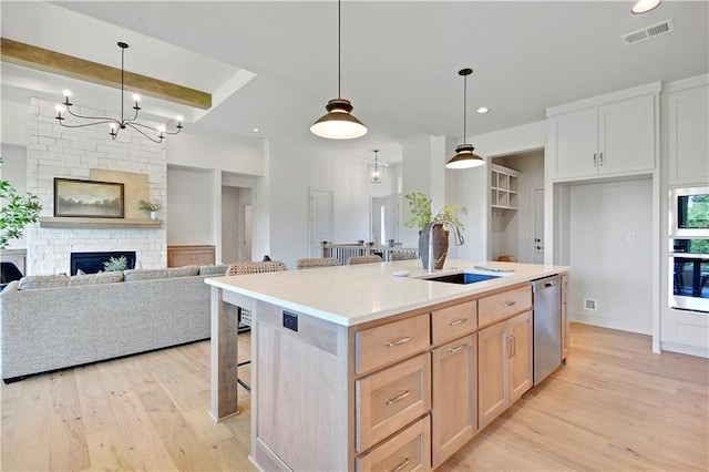 22063 W 100th Ter, Lenexa, KS 66220 - kitchen featuring appliances with stainless steel finishes, light wood-type flooring, light countertops, a breakfast bar, and a kitchen island with sink