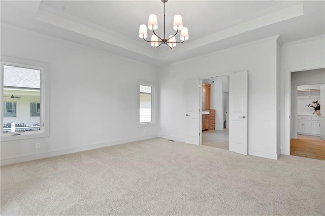22063 W 100th Ter, Lenexa, KS 66220 - unfurnished bedroom featuring a tray ceiling, light carpet, crown molding, and a chandelier