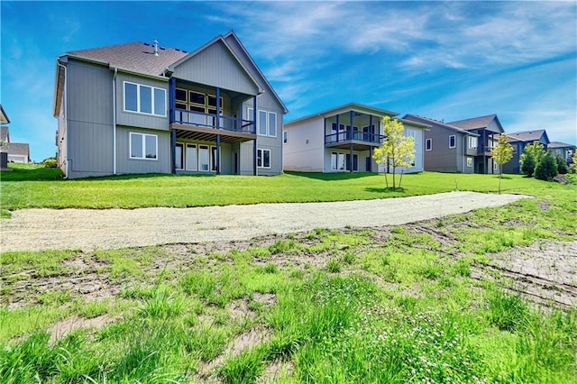 22063 W 100th Ter, Lenexa, KS 66220 - rear view of property with a balcony, a lawn, and a residential view