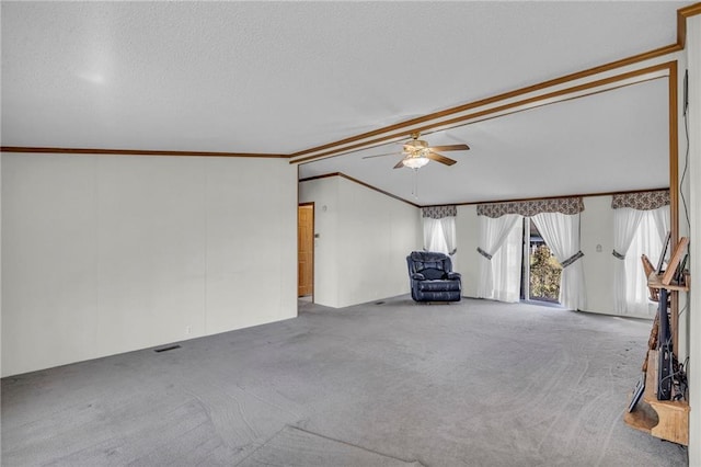 unfurnished living room featuring carpet floors, ceiling fan, lofted ceiling, ornamental molding, and a textured ceiling